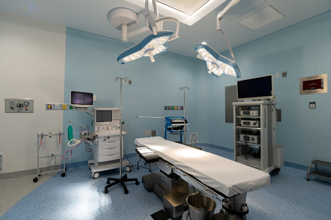 An operating room with bed and different types of medical equipment.